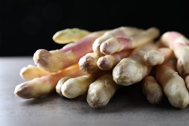 Photo of Pile of fresh white asparagus on grey table, closeup