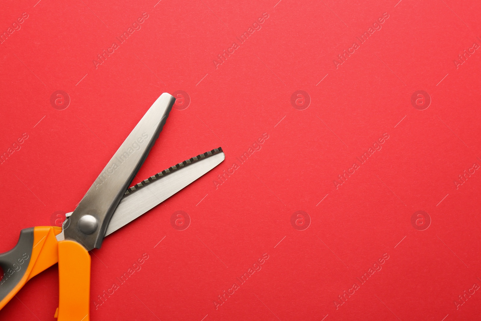 Photo of Pair of sharp scissors on color background, top view. Space for text