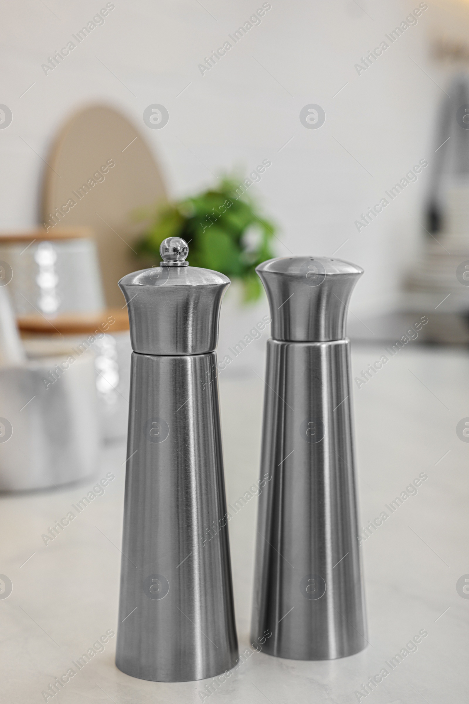 Photo of Stainless steel salt and pepper shakers on table