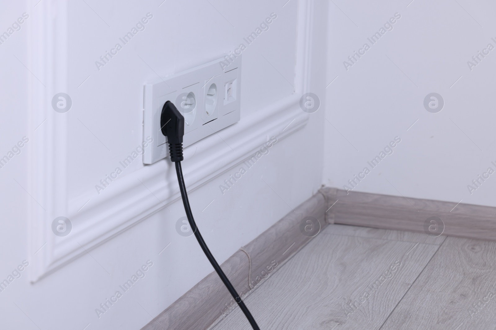 Photo of Power sockets and electric plug on white wall, space for text