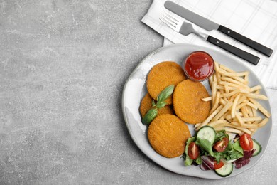 Photo of Delicious fried breaded cutlets with garnish served on grey table, flat lay. Space for text