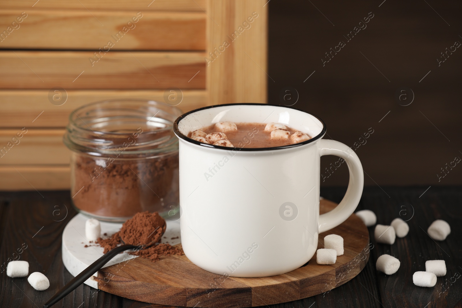 Photo of Cup of aromatic hot chocolate with marshmallows and cocoa powder served on table