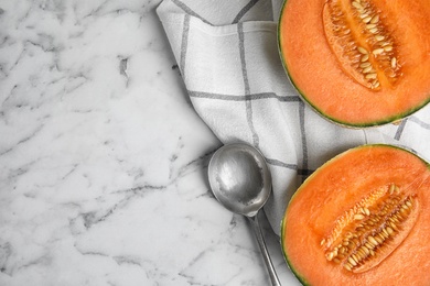 Flat lay composition with ripe cantaloupe melon on white marble table. Space for text