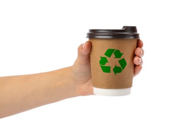 Woman holding takeaway paper coffee cup with recycling symbol on white background, closeup