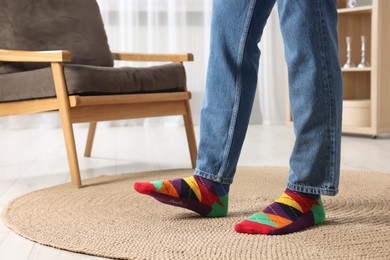Photo of Man in stylish colorful socks and jeans indoors, closeup. Space for text