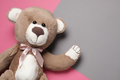 Photo of Cute teddy bear on color background, top view. Space for text