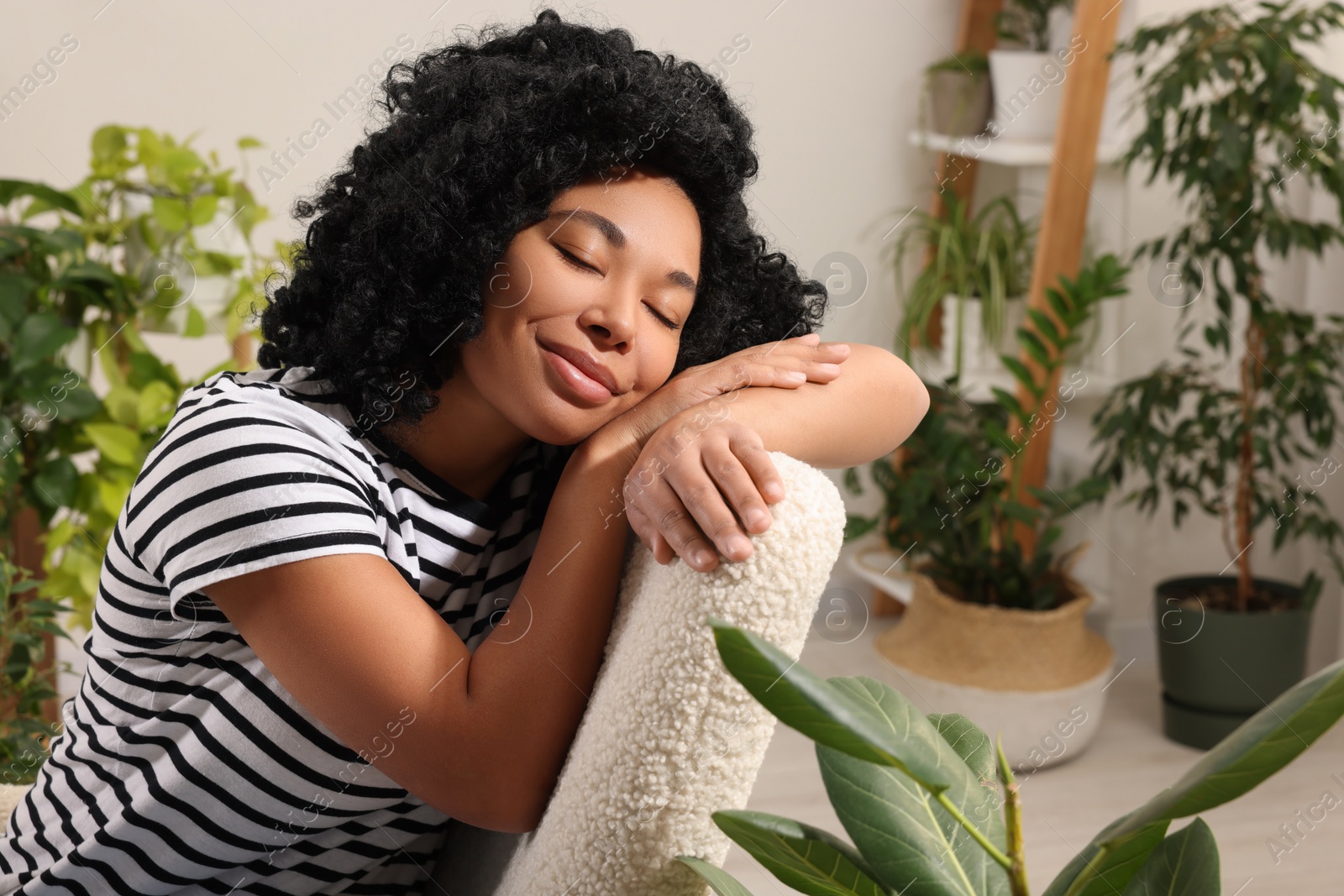 Photo of Woman relaxing surrounded by beautiful houseplants at home