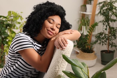 Woman relaxing surrounded by beautiful houseplants at home