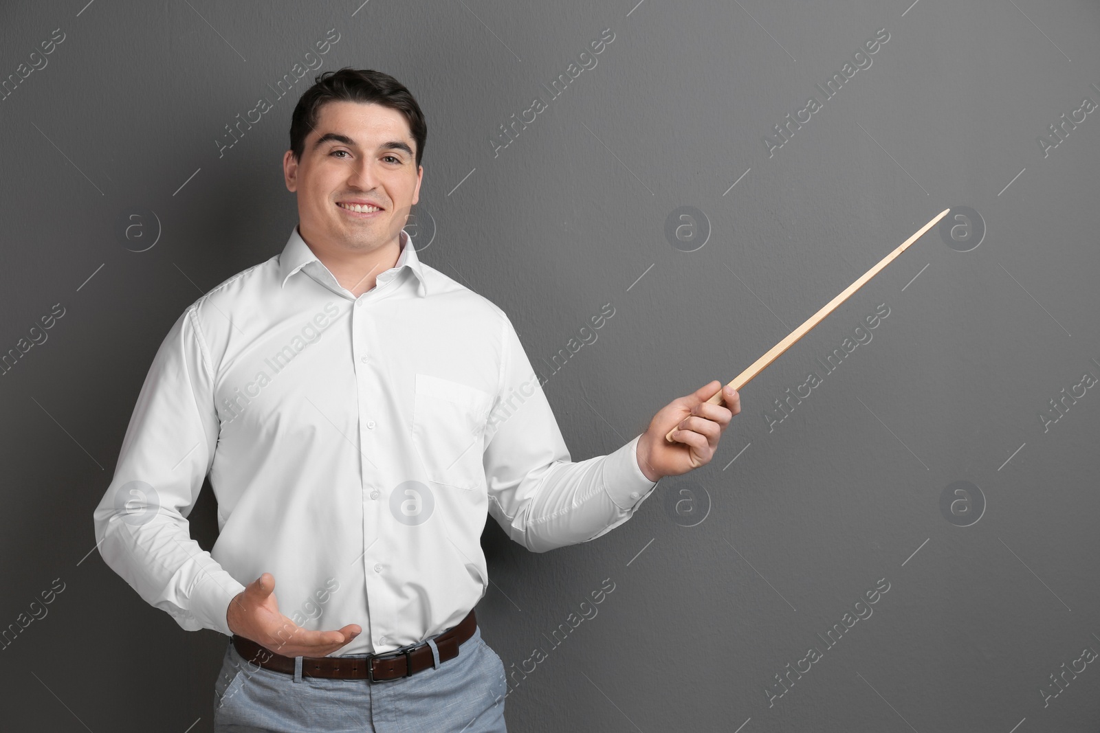 Photo of Portrait of male teacher with pointer on grey background