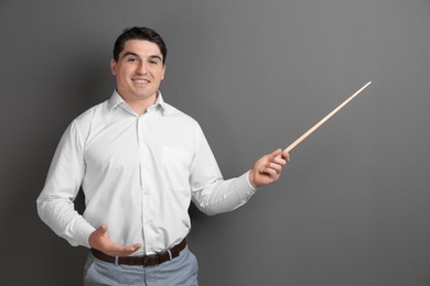 Photo of Portrait of male teacher with pointer on grey background