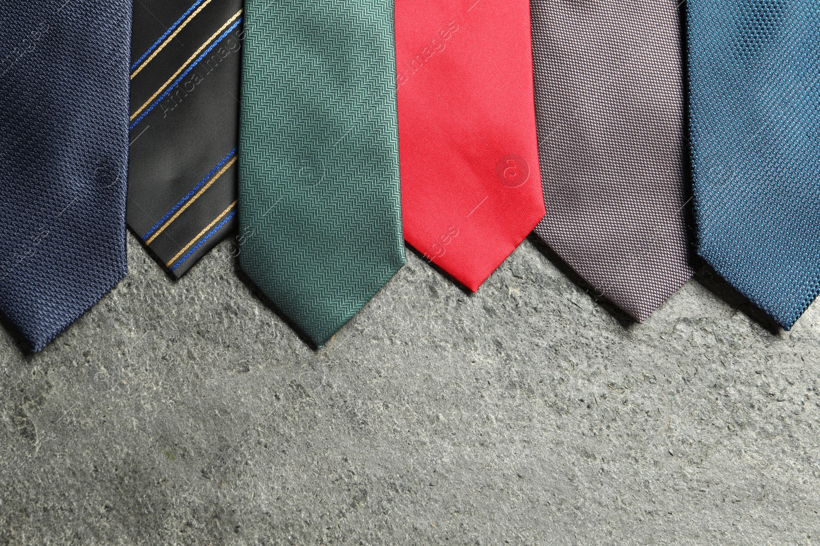 Photo of Different neckties on grey textured background, flat lay. Space for text