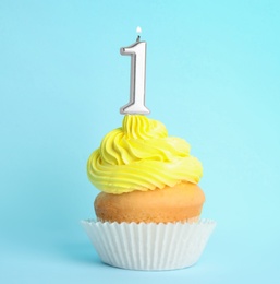 Photo of Birthday cupcake with number one candle on blue background