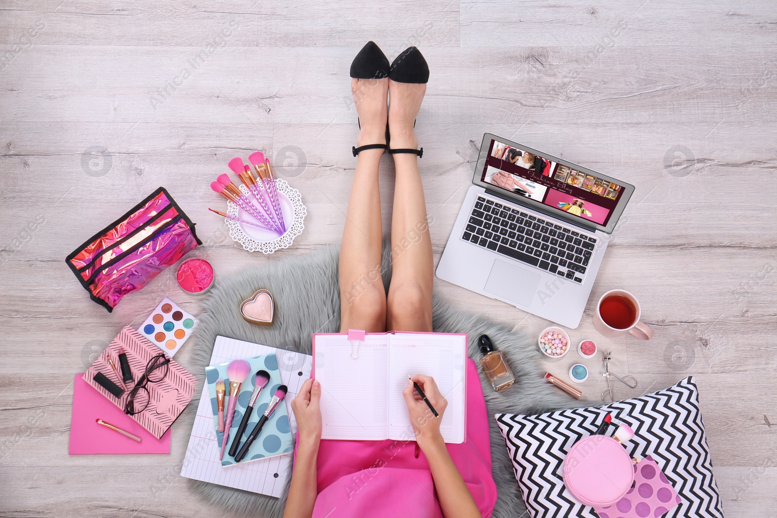 Photo of Beauty blogger with laptop and cosmetics sitting on floor, top view