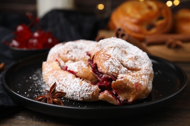 Photo of Delicious buns with berries, sugar powder and anise star on table, closeup