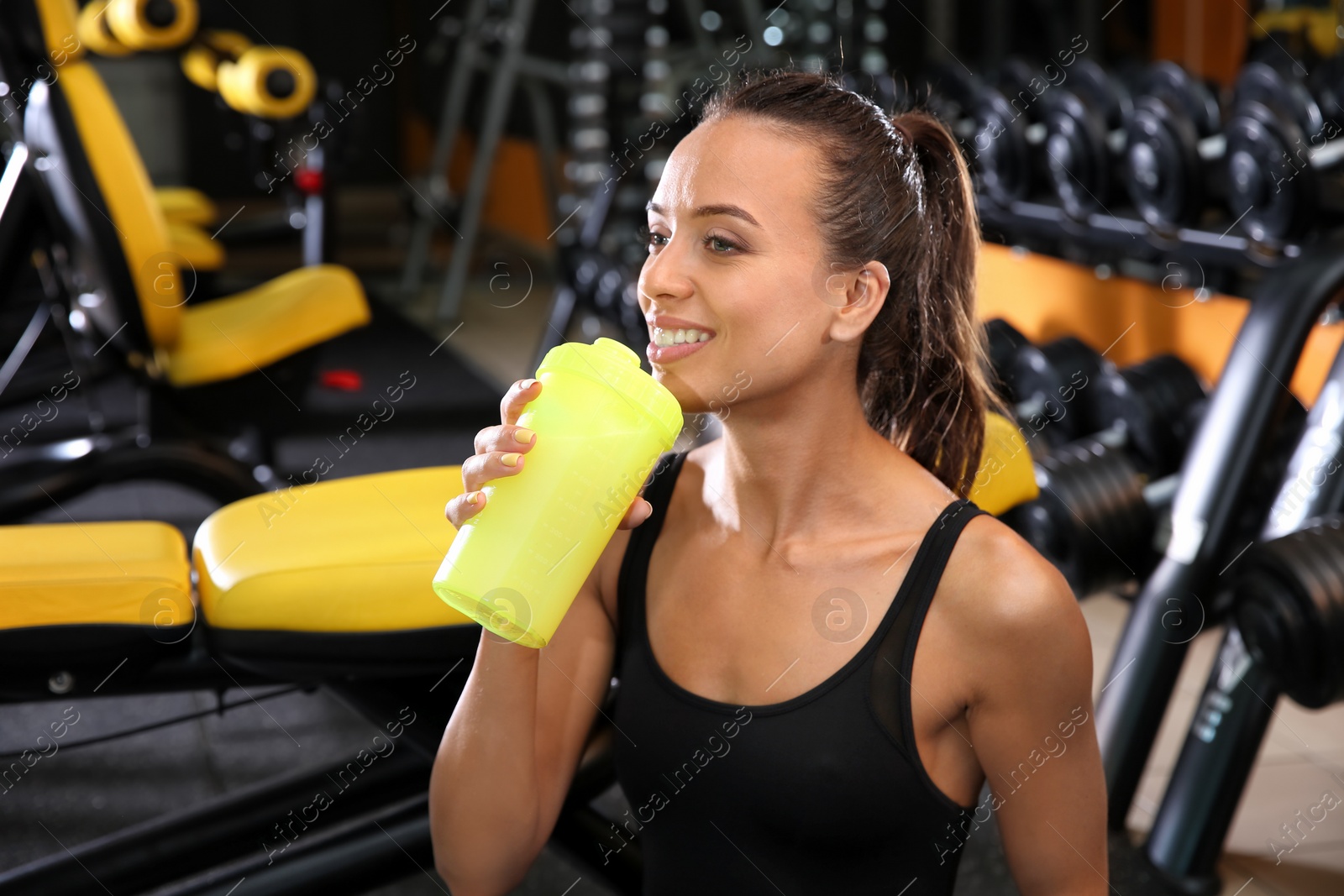 Photo of Portrait of athletic woman with protein shake in gym