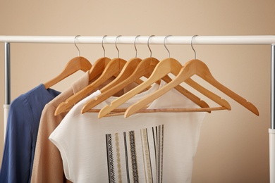 Photo of Female clothes on wardrobe rack on color background