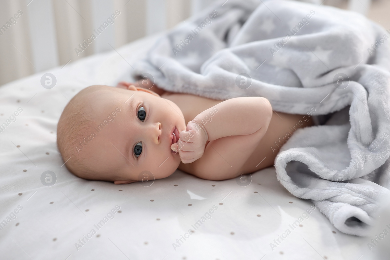 Photo of Cute little baby lying in crib at home