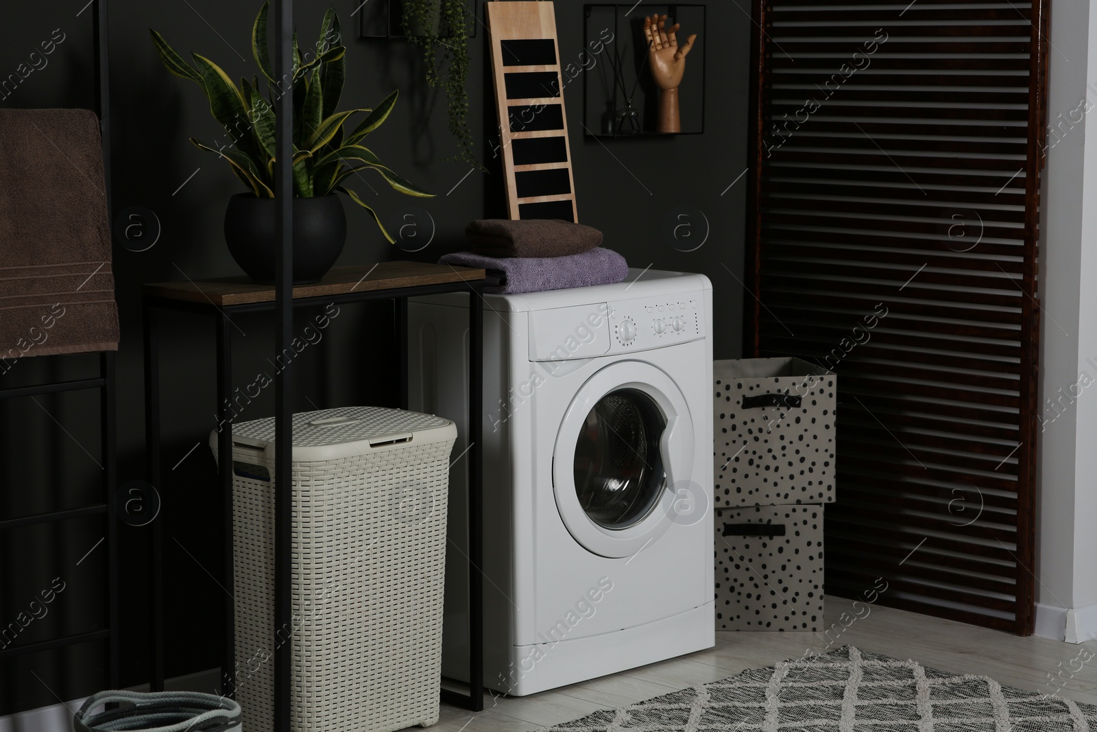 Photo of Stylish laundry room with washing machine. Interior design