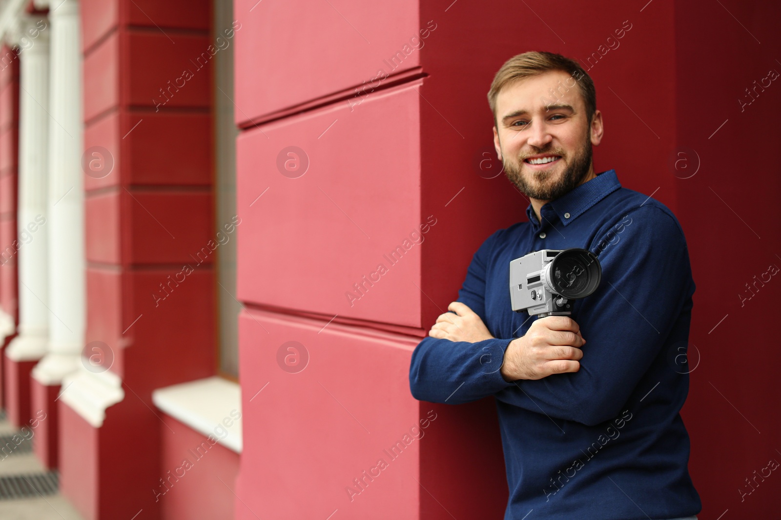 Photo of Young man with vintage video camera outdoors