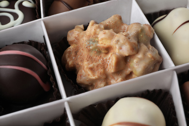 Photo of Delicious chocolate candies in box, closeup view