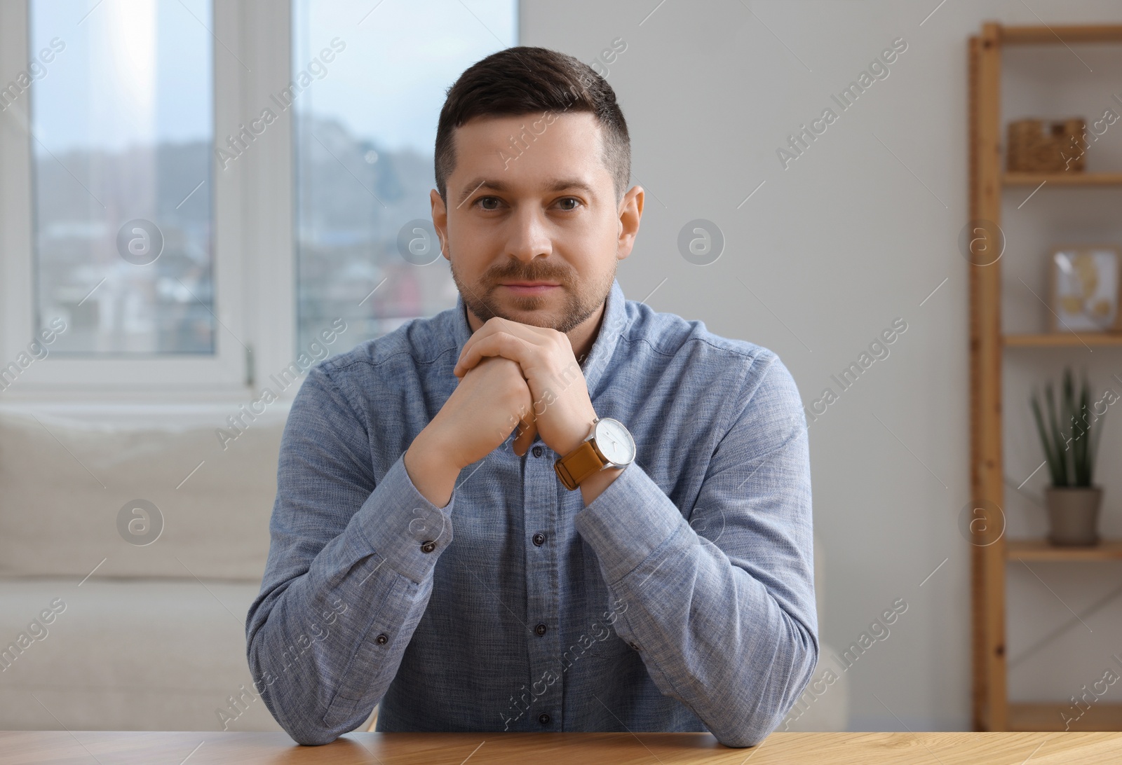 Photo of Man having video call at wooden table indoors, view from web camera