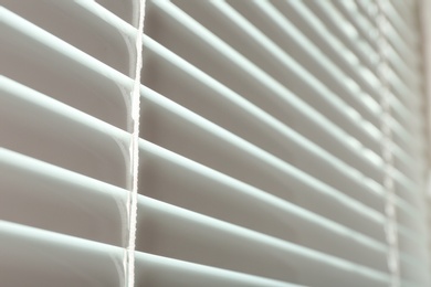 Photo of Closed modern white window blinds, closeup view