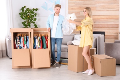 Young couple near wardrobe boxes at home