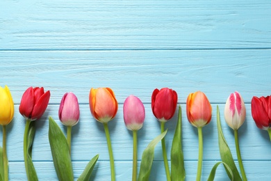 Photo of Beautiful tulips and space for text on wooden background, top view. Spring flowers