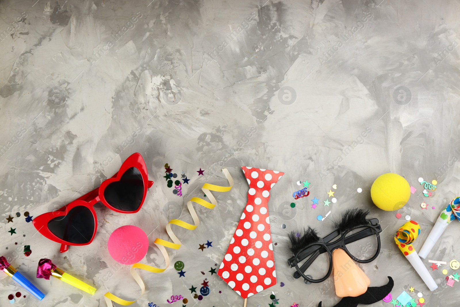 Photo of Flat lay composition with clown's items on grey stone table, space for text