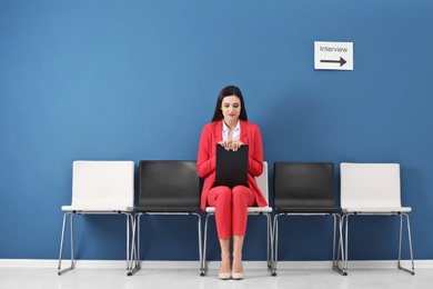 Young woman waiting for job interview, indoors