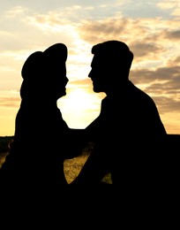 Image of Silhouette of lovely couple enjoying time together at sunset