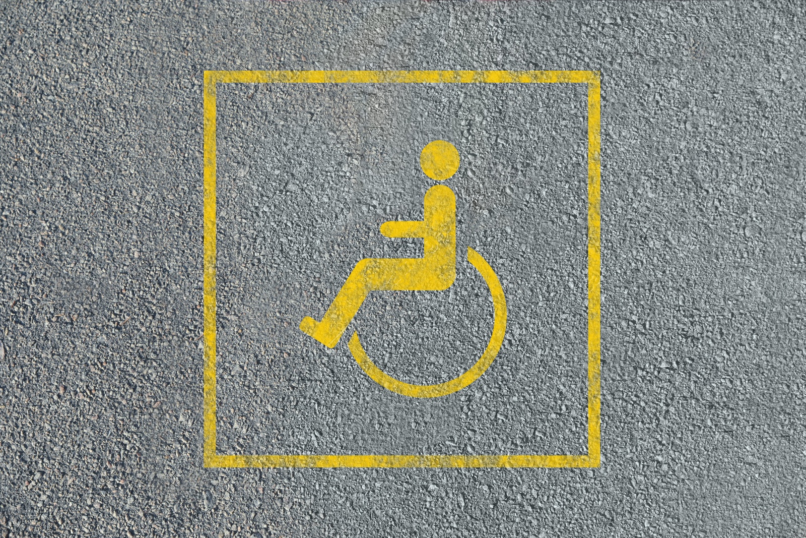 Image of Wheelchair symbol on asphalt road, top view. Disabled parking permit