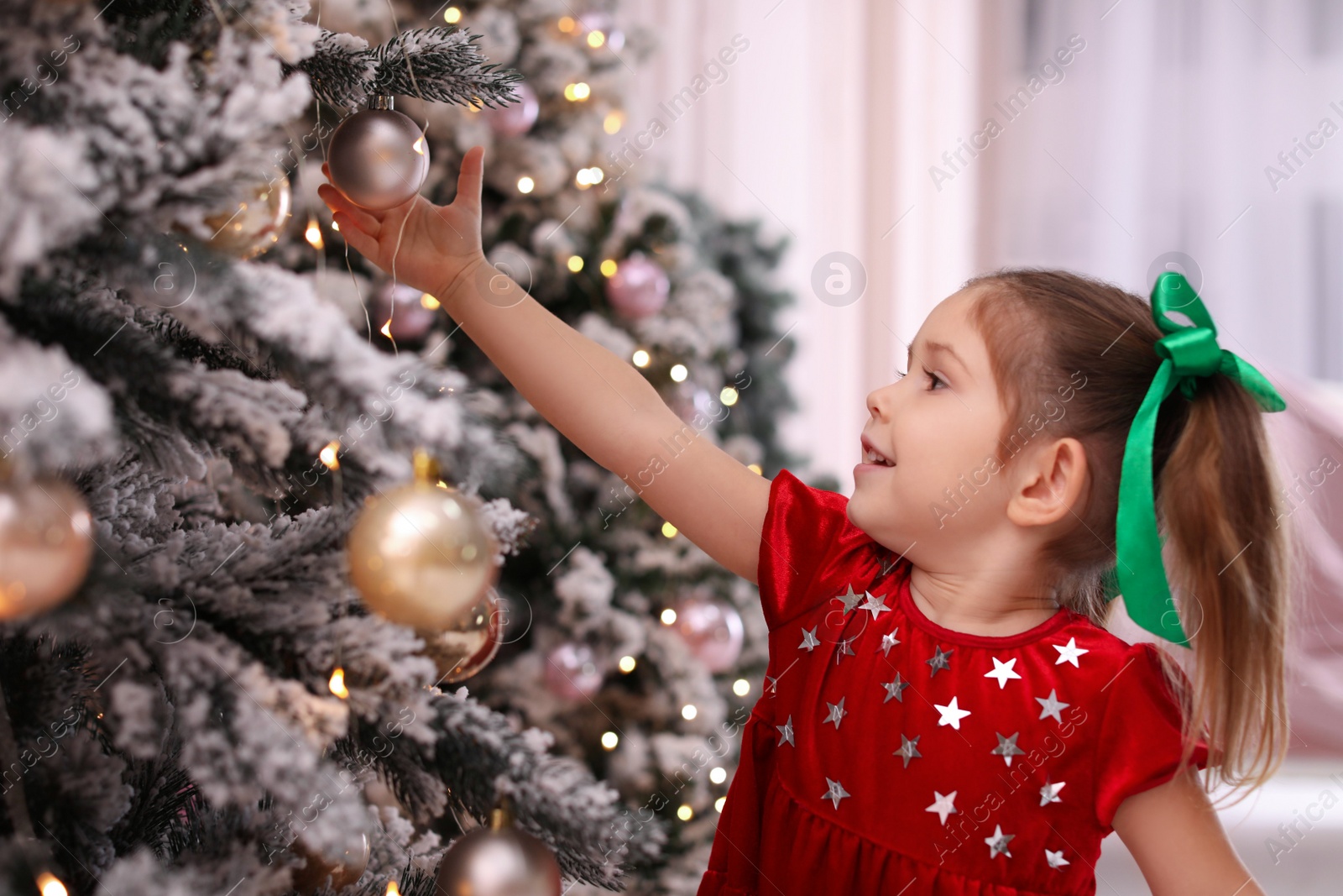 Photo of Cute little child near Christmas tree at home