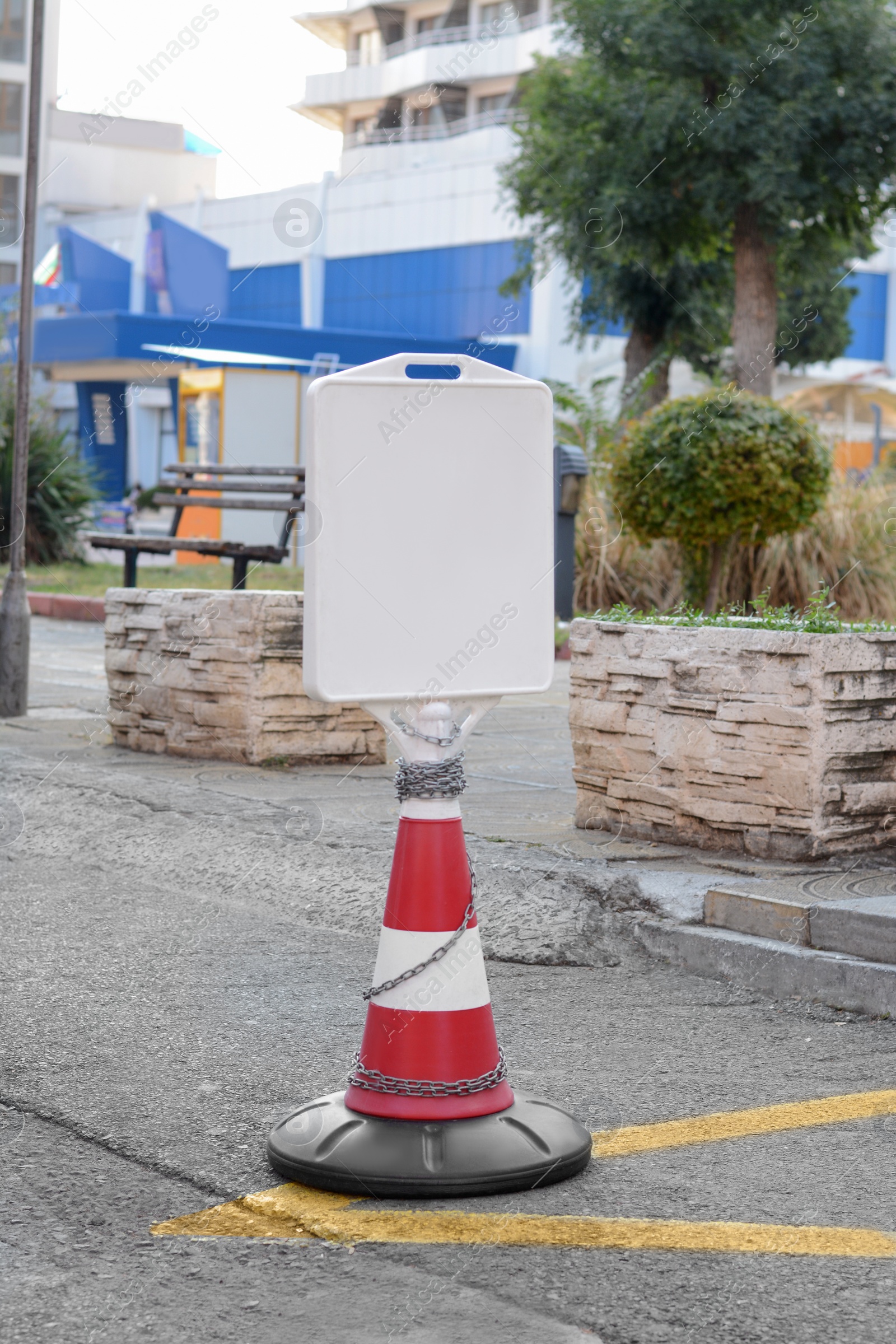 Photo of Traffic cone with blank sign on asphalt outdoors