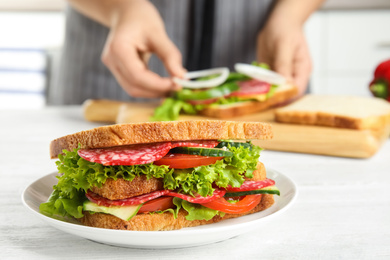 Photo of Tasty sandwich on white wooden table, closeup