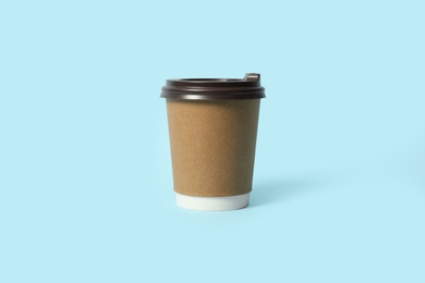 Photo of Takeaway paper coffee cup on light blue background