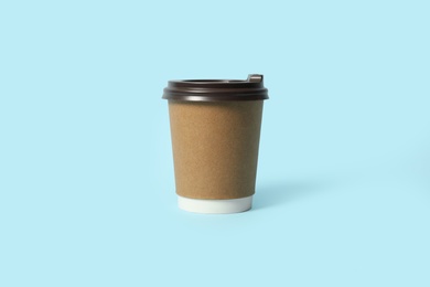 Takeaway paper coffee cup on light blue background