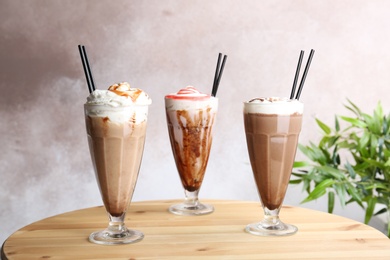 Glasses with delicious milk shakes on table