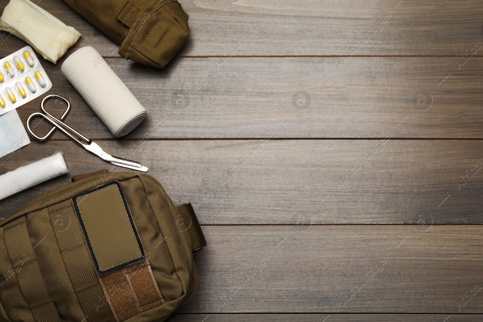 Photo of Military first aid kit on wooden table, flat lay. Space for text