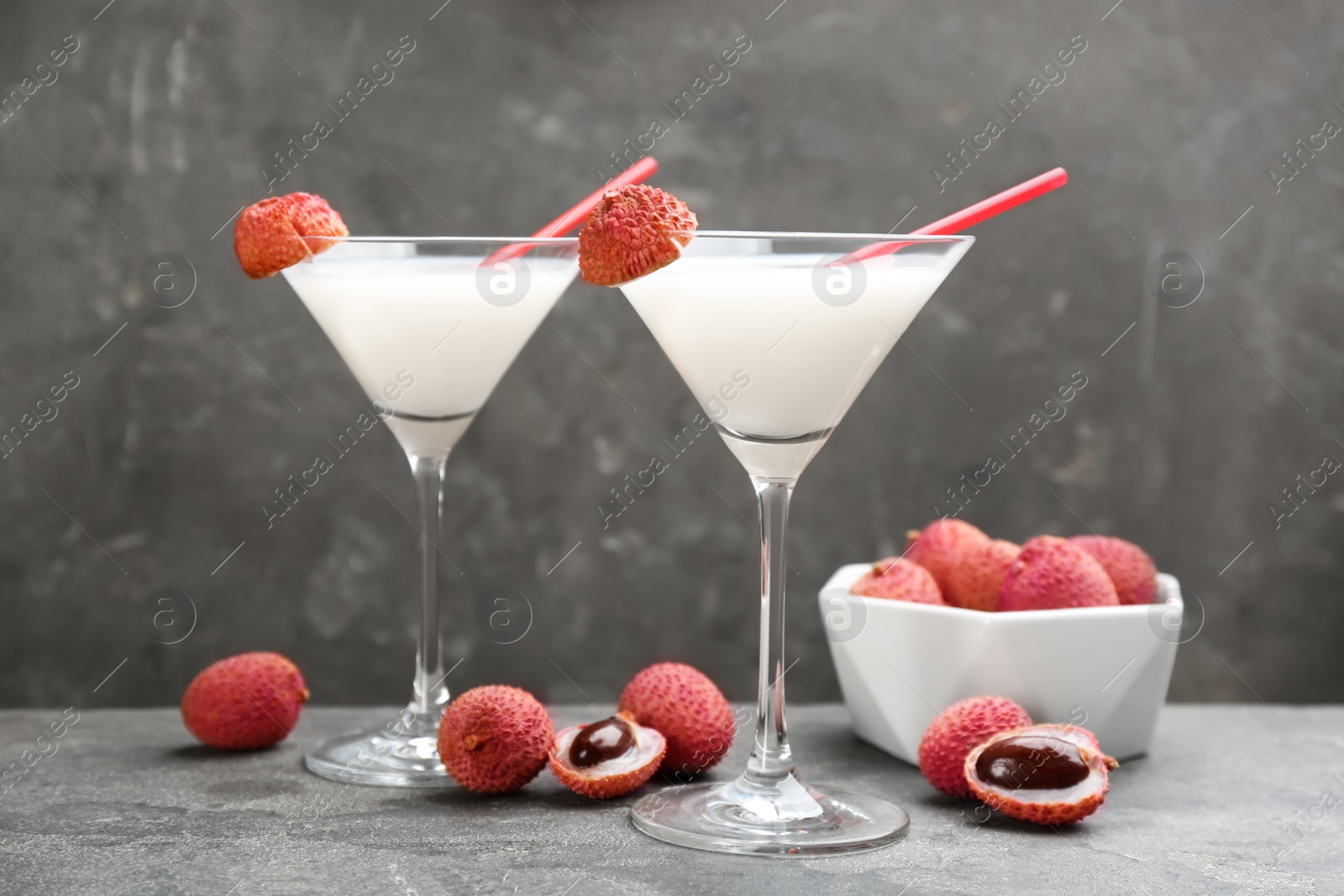 Photo of Lychee cocktail with fresh fruits on grey table