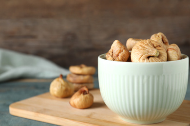 Tasty dried figs on blue wooden table, closeup. Space for text