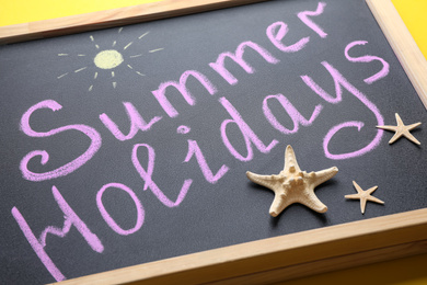 Photo of Chalkboard with phrase SUMMER HOLIDAYS, closeup view. School's out