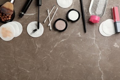 Dirty cotton pads, swabs, cosmetic products and micellar cleansing water on grey background, flat lay. Space for text