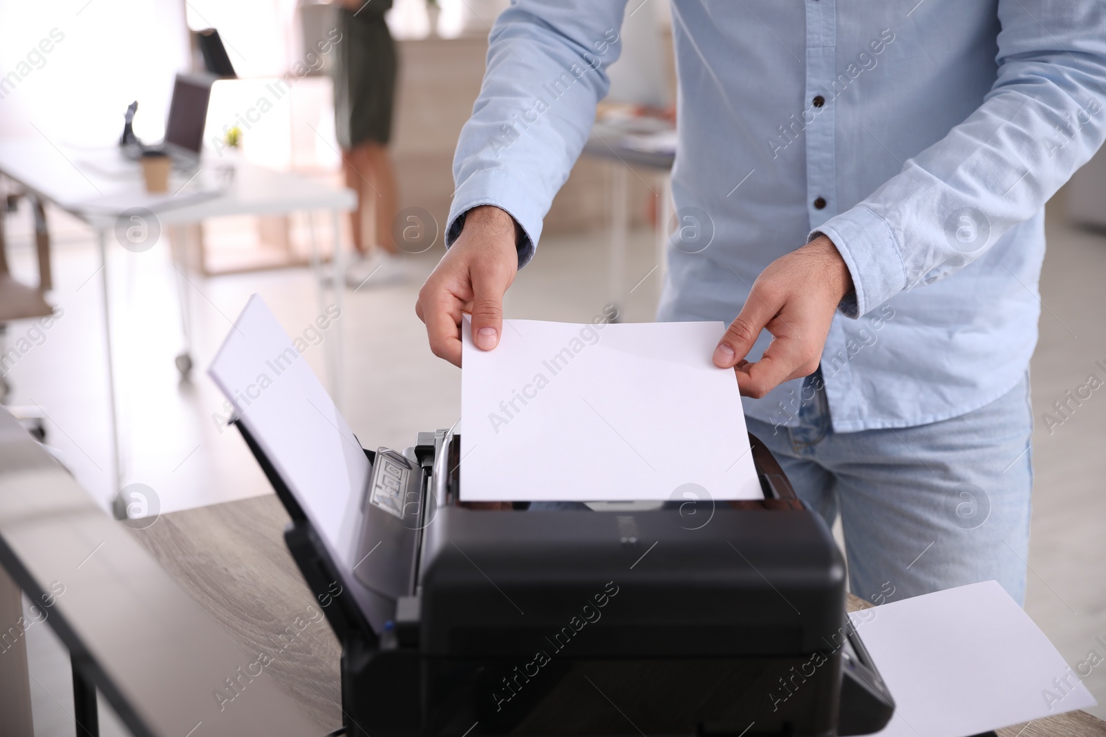 Photo of Employee using modern printer in office, closeup