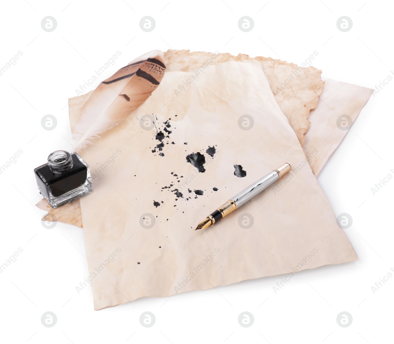 Photo of Parchment with stains of ink, feather pen and inkwell on white background