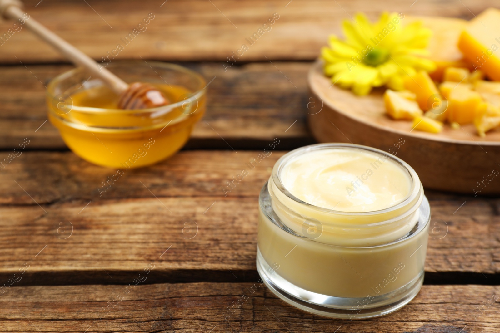 Photo of Cream with natural beeswax component on wooden table, closeup. Space for text