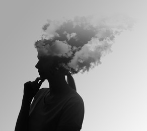 Image of Thoughtful woman with mist and clouds in head symbolizing amnesia on grey background