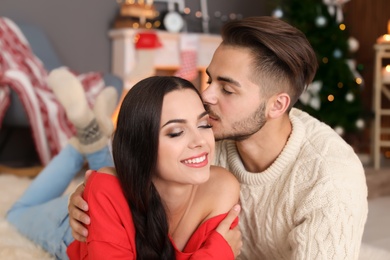 Photo of Happy young couple celebrating Christmas at home