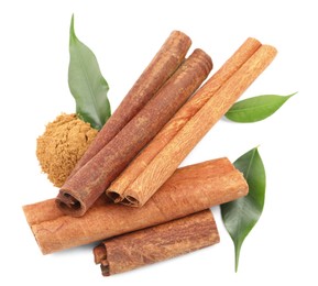 Photo of Dry aromatic cinnamon sticks, powder and green leaves isolated on white