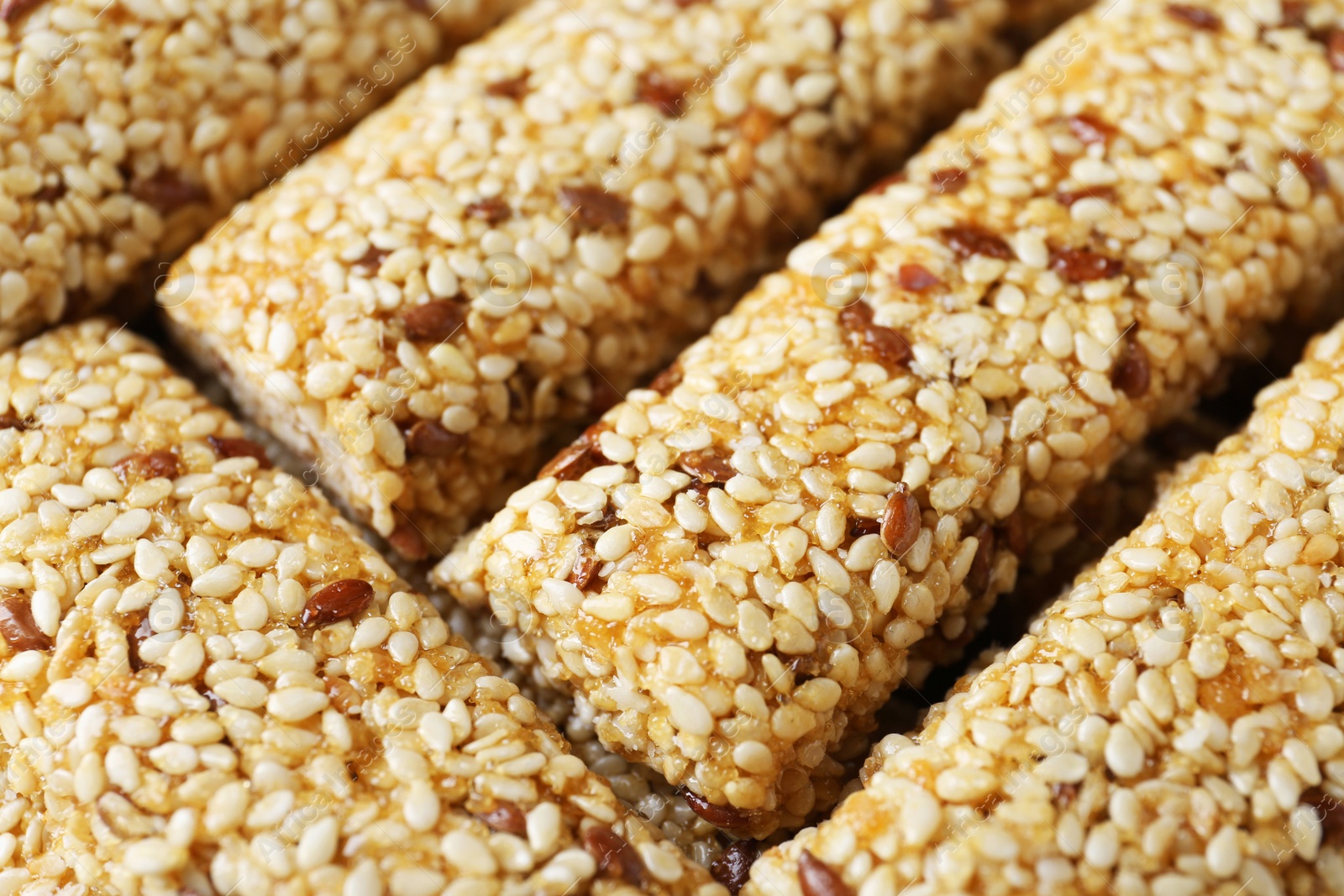 Photo of Tasty sesame seed bars as background, closeup